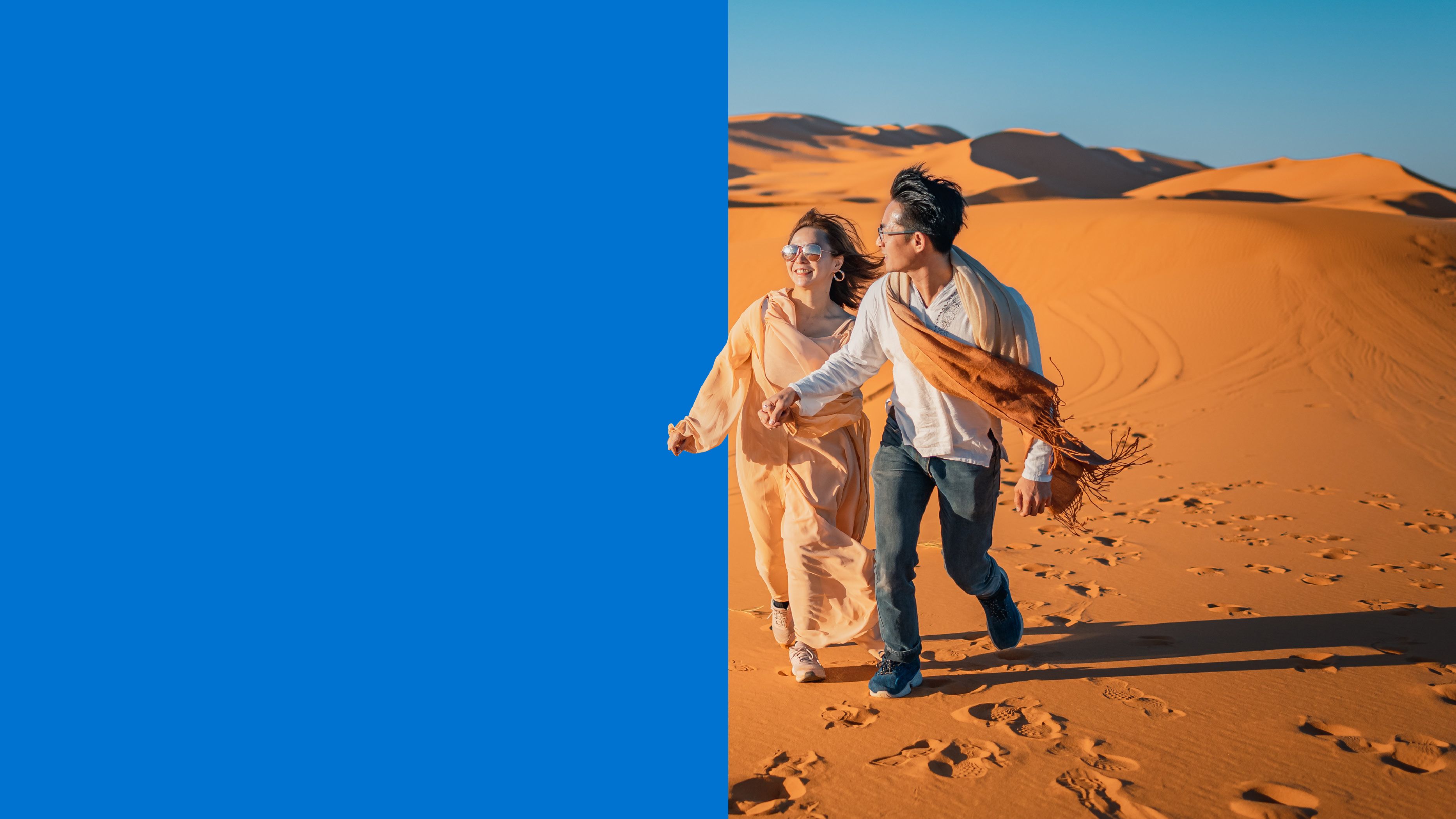 couple walking in sunset sand dune desert